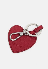 Red leather heart-shaped keychain with textured surface, silver hardware, a metal clip, and a branded circular ring.