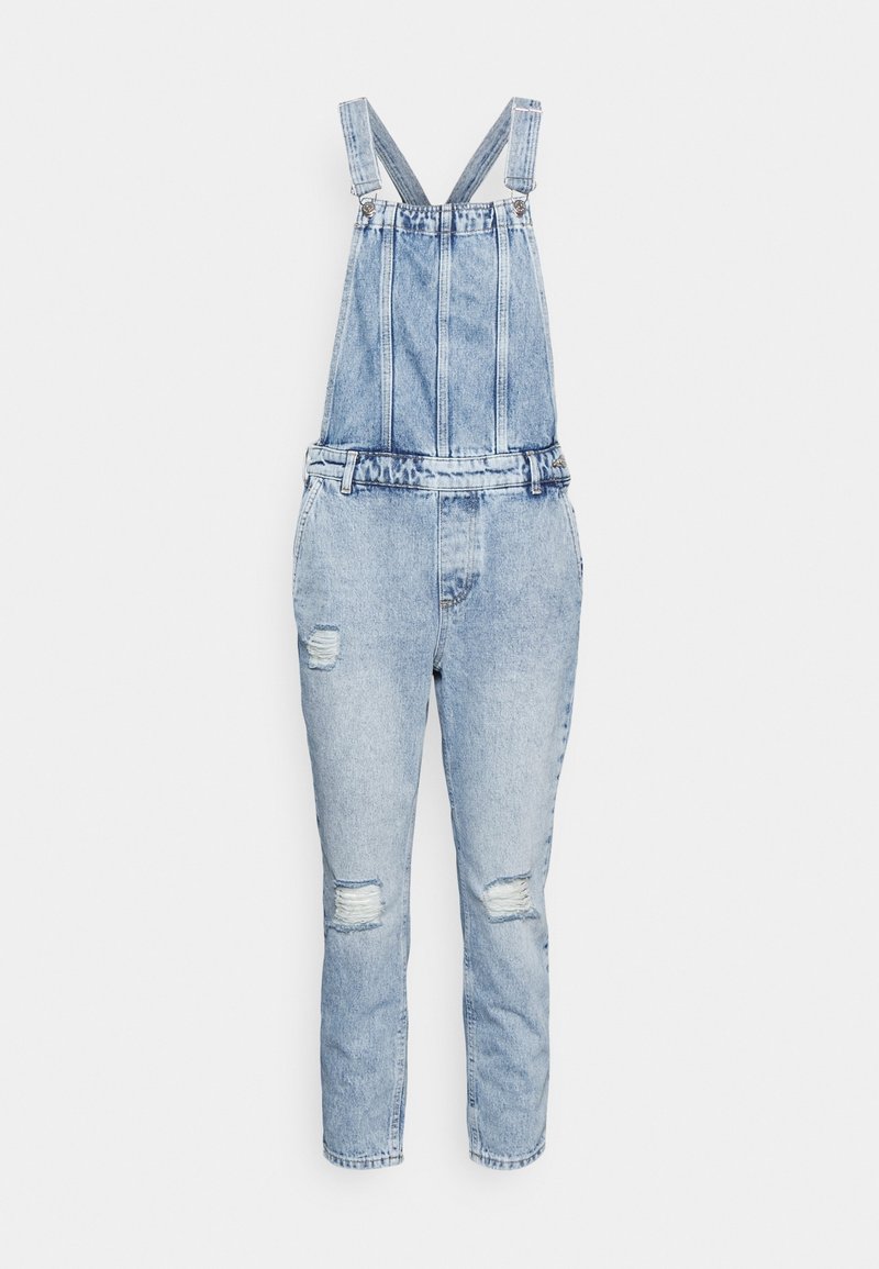 Salopette en denim bleu clair avec bretelles réglables et zones usées sur les cuisses et les genoux, présentée sur fond blanc.