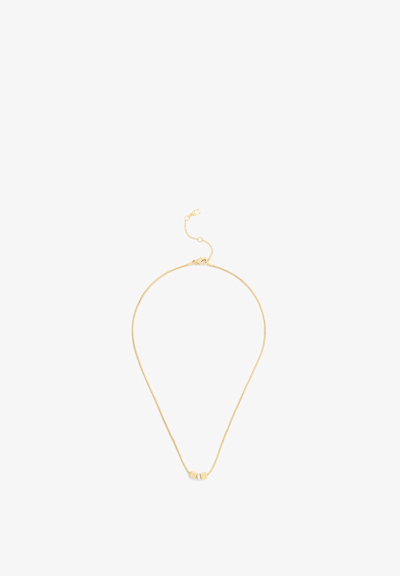 Collier délicat en chaîne dorée avec deux petits pendentifs carrés et un fermoir réglable sur fond blanc.