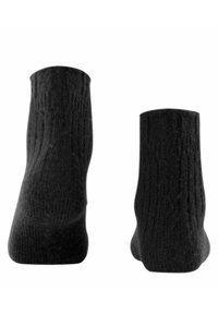 Calze nere lavorate a maglia con una texture a coste e lunghezza fino a metà polpaccio, caratterizzate da una finitura liscia e un design minimalista.