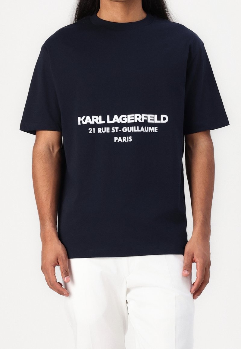 Granatowa bawełniana koszulka z krótkim rękawem, z białym nadrukiem: "KARL LAGERFELD 21 RUE ST-GUILLAUME PARIS" z przodu.