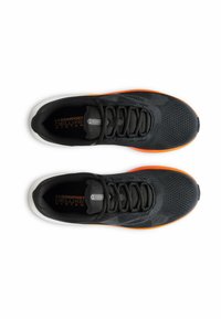 Chaussures de sport noires avec une tige en maille, un design texturé et une semelle en caoutchouc orange. Les caractéristiques comprennent des lacets et une semelle intérieure rembourrée étiquetée "Système Comfort Deluxe".