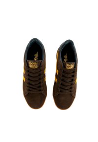Sneaker in suede marrone con strisce gialle, caratterizzati da un interno blu scuro e un'etichetta del marchio sulla linguetta. Lacci piatti e suole in gomma.