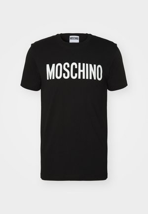Black cotton t-shirt featuring bold white "MOSCHINO" text across the front; crew neck and short sleeves. Simple design, classic fit.