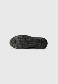 Black rubber shoe sole with a textured surface, featuring a grid pattern and ridges for traction. Designed for durability and comfort.