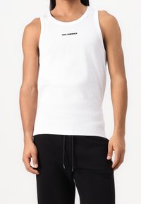 White cotton tank top with a crew neckline and ribbed texture, featuring a black "Karl Lagerfeld" logo centered on the chest.