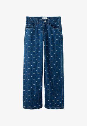 Sinine denim laiad sääred püksid, millel on vertikaalne triibumuster väikeste valgete paelte motiividega. Sisaldab ees olevaid taskuid ja nupuga sulgemist.