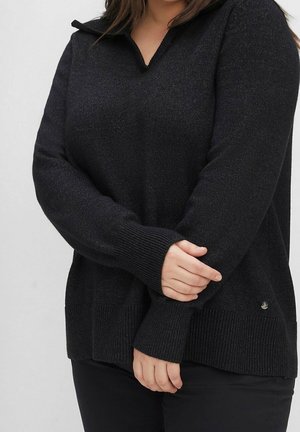 Schwarzer Pullover mit V-Ausschnitt und Kragen-Design, aus einem strukturierten Strickmaterial gefertigt. Rippbündchen und -saum, mit einem kleinen Hardware-Detail.