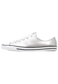 Silberne metallische Sneakers mit niedrigem Schnitt, schwarzer und weißer gestreifter Sohle, runder Zehenkappe und weißen Schnürsenkeln; glatte Textur und minimalistisches Design.