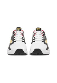 Sneakersy z białą siateczkową cholewką, czarnymi akcentami i żółtymi detalami. Czerwone sznurowadła, wyściełany język oraz teksturowana czarna gumowa podeszwa.