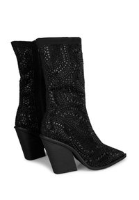 Bottes noires à talons mi-mollet avec des pointes effilées et des motifs géométriques en perles et clous recouvrant la surface.