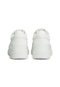 Baskets blanches avec une tige en cuir lisse, design basse, semelle en caoutchouc et "TOMMY JEANS" embossé sur le talon. Onglet de tirage à l'arrière pour un enfilage facile.