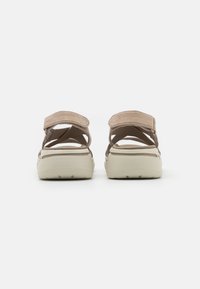 Bruine sandalen met een gekleurde bovenkant, verstelbare banden, een gevoerde zool en een gebogen vorm met een witte buitenzool.