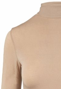 Maglione beige a collo alto realizzato in tessuto a costine. Caratterizzato da un design aderente con un colletto alto e maniche lunghe, texture liscia e senza fantasie.