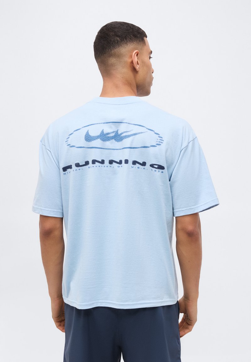 Nike Performance CREW SHORT LOOSE TOR - Triko s potiskem - light armory blue/thunder blue