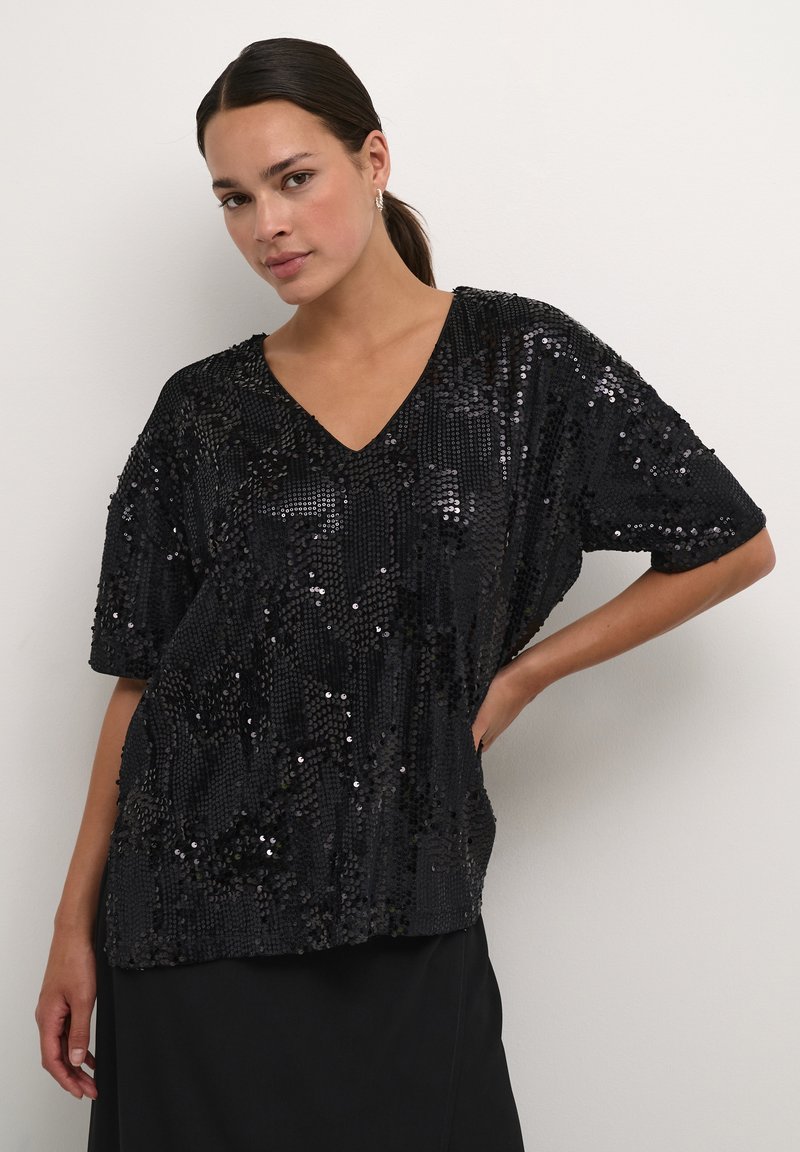 Black sequined top with short sleeves and a V-neck. Features a loose, relaxed fit and a textured surface created by the sequins.