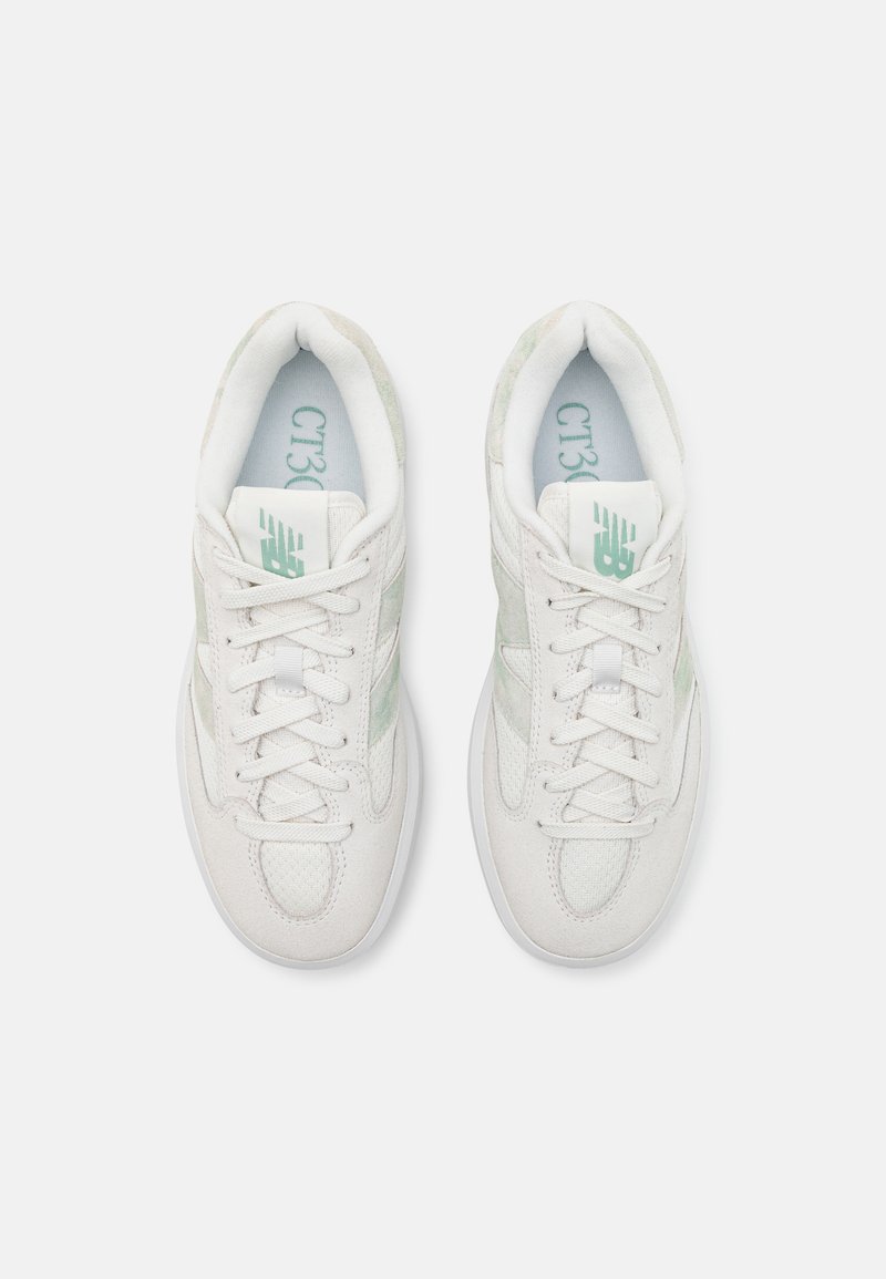 Sneakers bianchi con tomaia in mesh traspirante e suede. Presentano dettagli verdi, lacci piatti e una collo imbottito per un maggiore comfort.