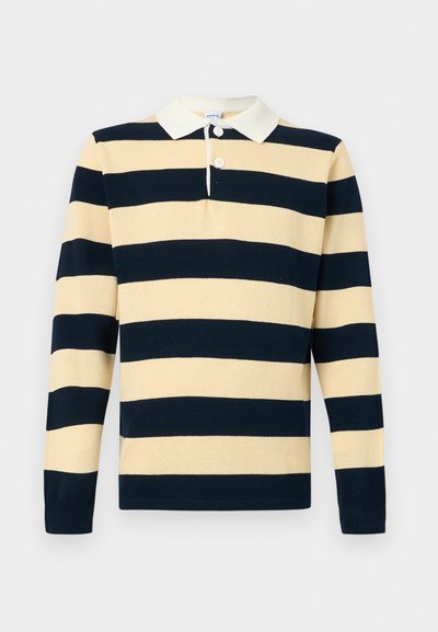 Chemise de rugby en maille à manches longues avec de larges rayures horizontales bleu marine et beige, col blanc et deux boutons blancs au niveau de l'encolure.