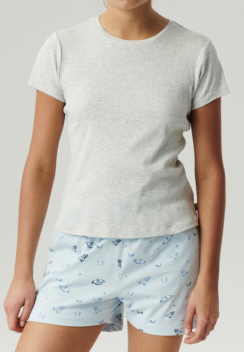 Szara koszulka z krótkim rękawem i okrągłym dekoltem, w połączeniu z jasnoniebieskimi szortami z motywem motyli w odcieniach niebieskiego.