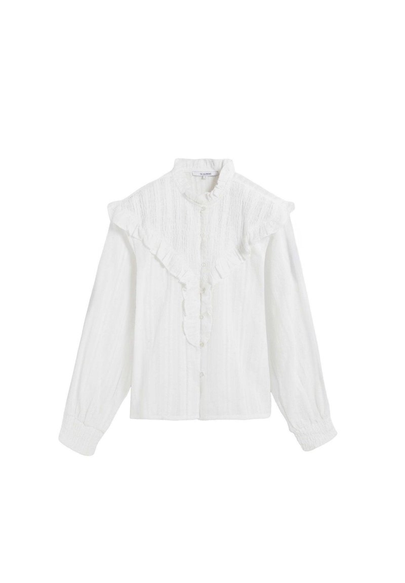 Blusa blanca con cuello volado, botón al frente y mangas largas. La tela texturizada presenta sutiles líneas verticales.
