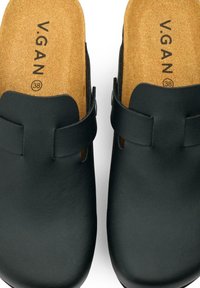Black vegan leather clogs with a cork footbed, featuring a horizontal strap and a rounded toe design. Size 38 marked on the insole.