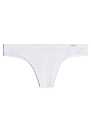 Tanga blanca de tela suave, con un diseño minimalista, tirantes finos y una etiqueta en la cintura.
