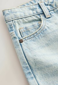 Svetlomodré džíny z denimu s klasickým dizajnom piatich vreciek, viditeľným šitím a malým bronzovým nýtom na prednom vrecku.