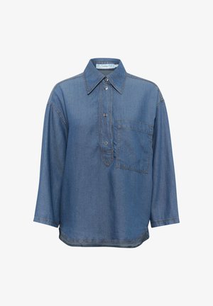 Sininen farkkupaita, jossa on terävä kaulus, pitkät hihat, nappilista edessä ja yksi rintatasku. Erityispiirteenä on kontrastivärinen ompelu.