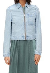 Helles blaues Jeansjacke mit einem Frontreißverschluss und einer Brusttasche, mit einem cropped Design und einer glatten Textur.