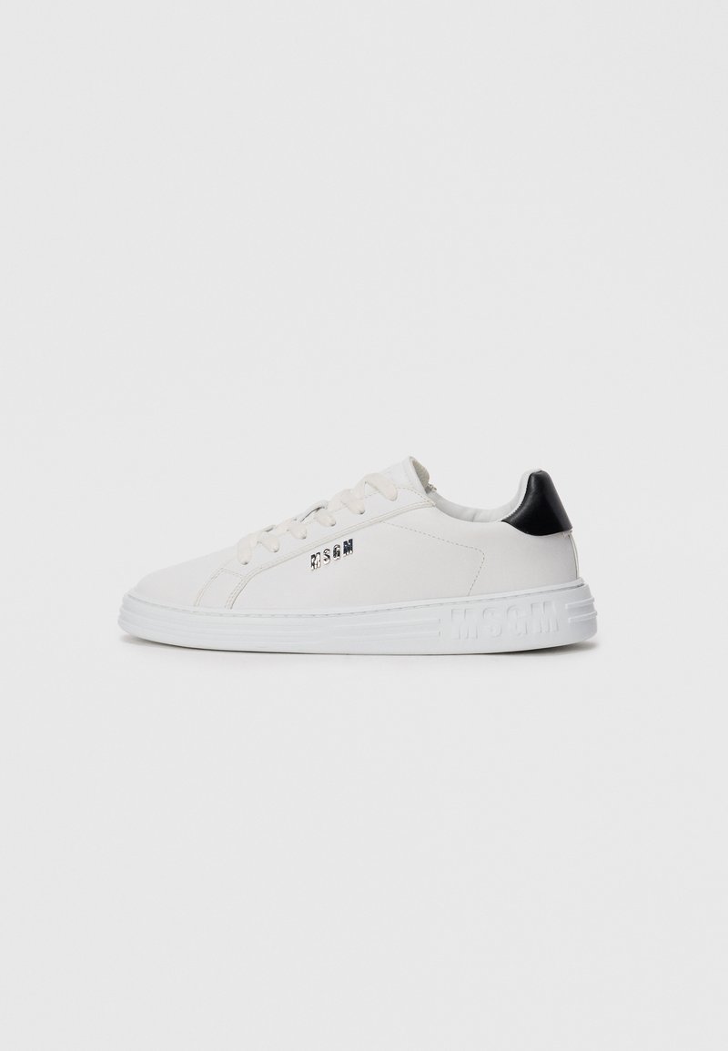 Hvit lavtopp sneakers med snøring foran, svart hælflik og "MSGM"-logo på siden og sålen, mot en ensfarget bakgrunn.