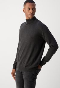 Mørkegrå turtleneck sweater i et blødt strikket stof. Har ribbede kanter ved kraven og манchetter, med en afslappet pasform og en ren finish.