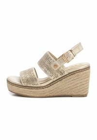 Sandalia cuña con correas sintéticas doradas perforadas, hebilla ajustable y suela envolvente de yute. Plantilla suave de color claro.