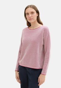Világos rózsaszín, kötött pulóver texturált mintával, kerek nyakkivágással és kontrasztos díszítéssel. Hosszú ujjú, laza fazonú és puha anyagból készült.