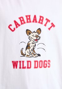 White cotton t-shirt featuring a cartoon dog illustration, with "CARHARTT" and "WILD DOGS" in bold red letters above and below.