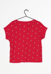 Rode T-shirt met korte mouwen met een herhalend patroon van witte bliksemschichten. Gemaakt van zachte stof met een relaxte pasvorm en een ronde hals.