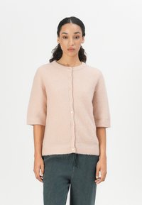 Light pink knit cardigan with a round neck, short sleeves, and button front. Soft texture with ribbed pattern and subtle sheen.