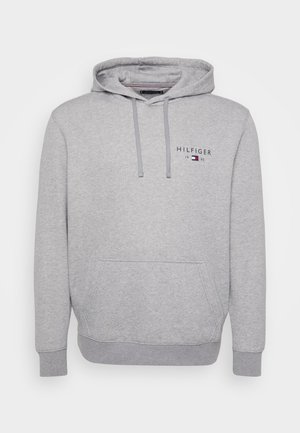 Haut à capuche gris clair avec une poche avant, capuche à cordon de serrage et logo de marque portant "HILFIGER 1985". Fabriqué en tissu doux en mélange de coton.