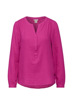 Blusa fucsia a maniche lunghe in tessuto leggero, con scollatura rotonda e pattina con bottoni, dotata di un orlo leggermente curvo. Spalle plissettate.