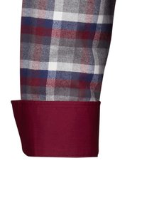 Manschetta della camicia scozzese con un pattern a quadri grigi, rossi e bianchi, abbinata a una manschetta di un solido bordeaux. Materiale in cotone con una texture liscia.