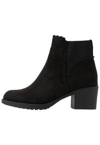 Czarne zamszowe botki za kostkę z falbaniastymi detalami, elastycznymi panelami po bokach i grubym obcasem. Teksturowana powierzchnia z okrągłym noskiem.