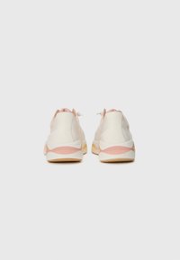 White and light pink sneakers with a textured fabric upper, rounded shape, and a thick, contrasting sole. Adjustable lacing system at the back.
