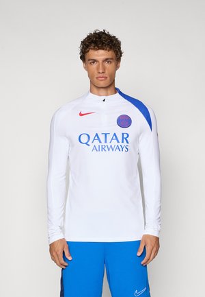 Bela športna majica z dolgimi rokavi z modrim poudarkom na ramenu in rdečim logotipom Nike. Spredaj je v debelih modrih črkah napis "QATAR AIRWAYS".