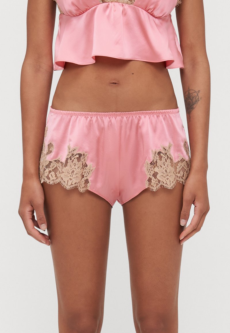 Roze satijnen shorts met gegolfde randen, voorzien van ingewikkelde beige kantaccenten aan de zijkanten en een elastische tailleband voor comfort.