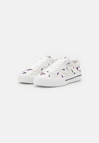 Weiße Canvas-Sneaker mit einem Muster von lila Traubenbüscheln und grünen Blättern. Flache Sohle, runde Zehenpartie und weiße Schnürsenkel. Schwarze Akzentkontur entlang der Sohle.
