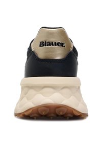 Schwarzer Sportschuh mit strukturiertem Obermaterial, goldenen Akzenten und einer dicken weißen Sohle mit konturiertem Muster und Gummistollen.