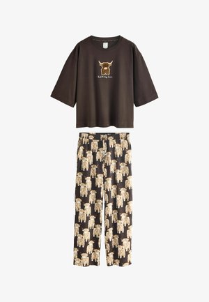 Donkerbruine korte mouwen shirt met stiergezicht grafiek en bijpassende broek met herhaalde lichtbruine stier illustraties op een zwarte achtergrond.