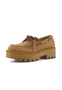 Chaussure en daim brun à plateforme avec une semelle épaisse et crantée, et des lacets bordeaux passant à travers des œillets dorés sur fond blanc.