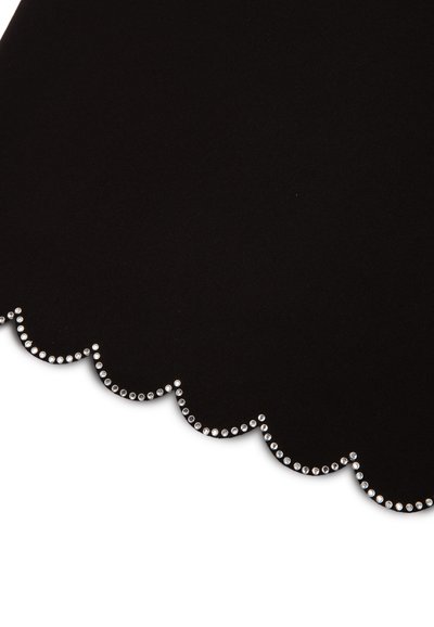 Tissu noir avec un bord festonné, orné d'une rangée de petits strass ronds transparents le long de l'ourlet. Détail de surface texturée.