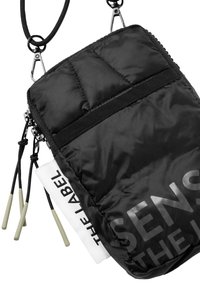 Black quilted pouch with a textured surface, featuring a zip closure and adjustable strap. Includes contrasting label detail and accent pulls.