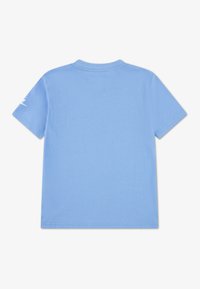 Ανοιχτό μπλε κοντομάνικο T-shirt με στρογγυλή λαιμόκοψη. Απαλό ύφασμα, απλός σχεδιασμός, χωρίς ορατά μοτίβα. Μικρό λευκό λογότυπο σε ένα μανίκι.